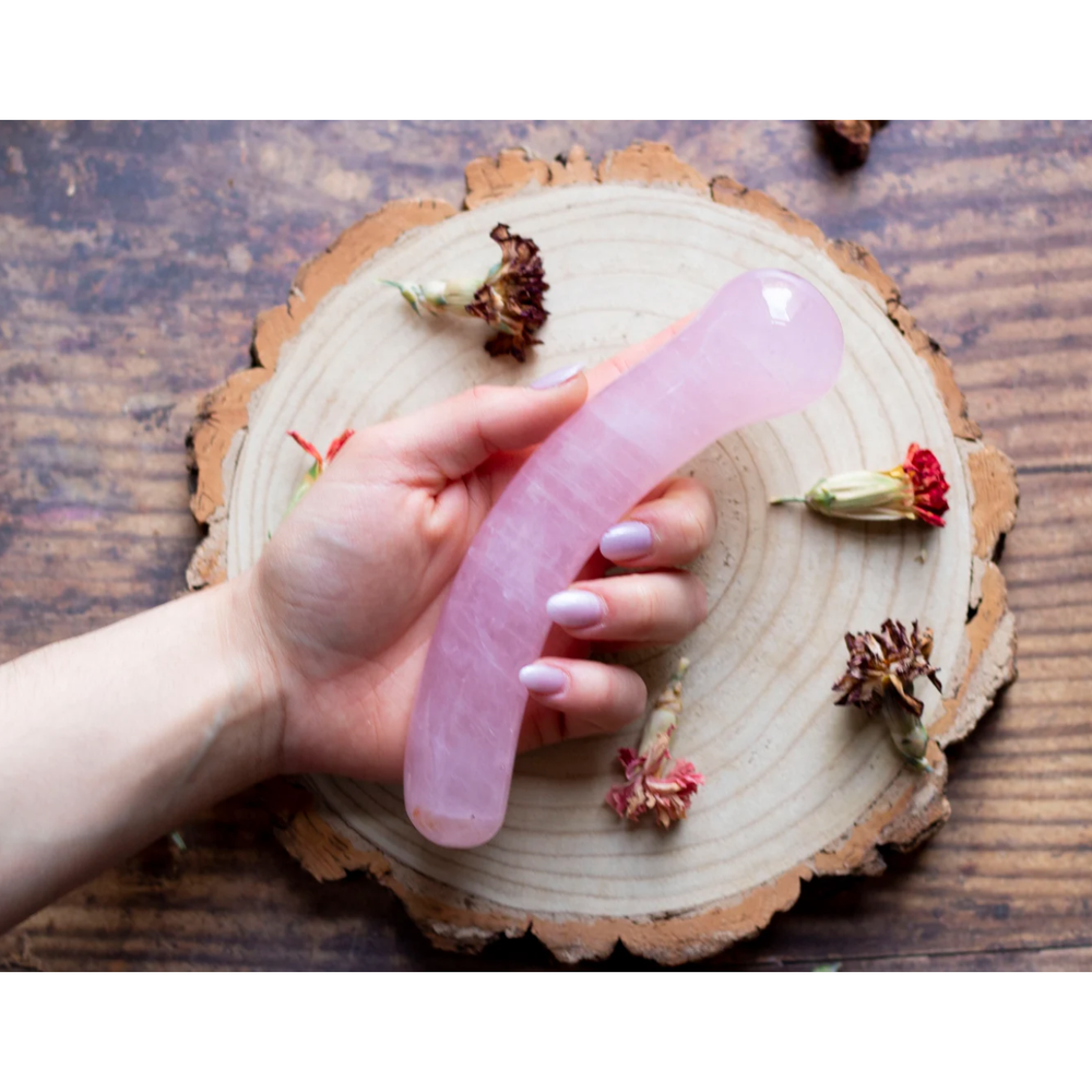 Girl holding curved yoni quartz crystal 